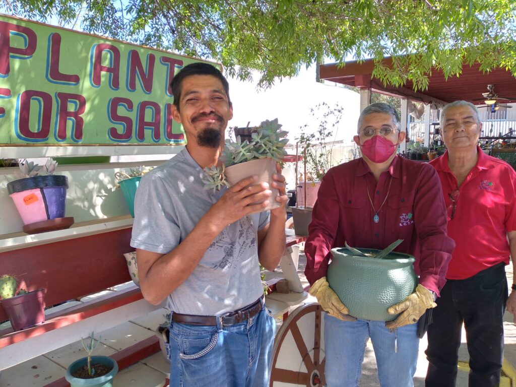 A member and supervisors displaying plants for sale.