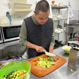 Apprentice chopping salad ingredients