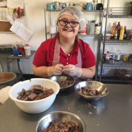 Apprentice shredding meat for dishes