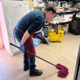 Apprentice mopping the kitchen floor.