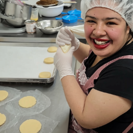 Apprentice baker filling caramel cookies with cajeta