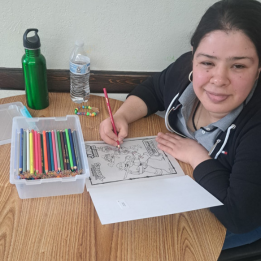 A young lady coloring with colored pencils