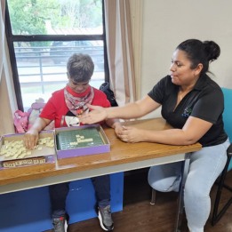 A lady and staff person play a word game