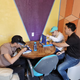 Two young men and a staff person playing games at a table