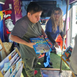 A young man choosing a book to read from the traveling library.